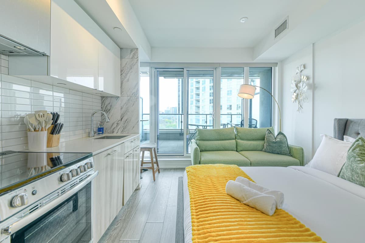 Real furnished downtown Toronto suite with kitchen, seating area and bed