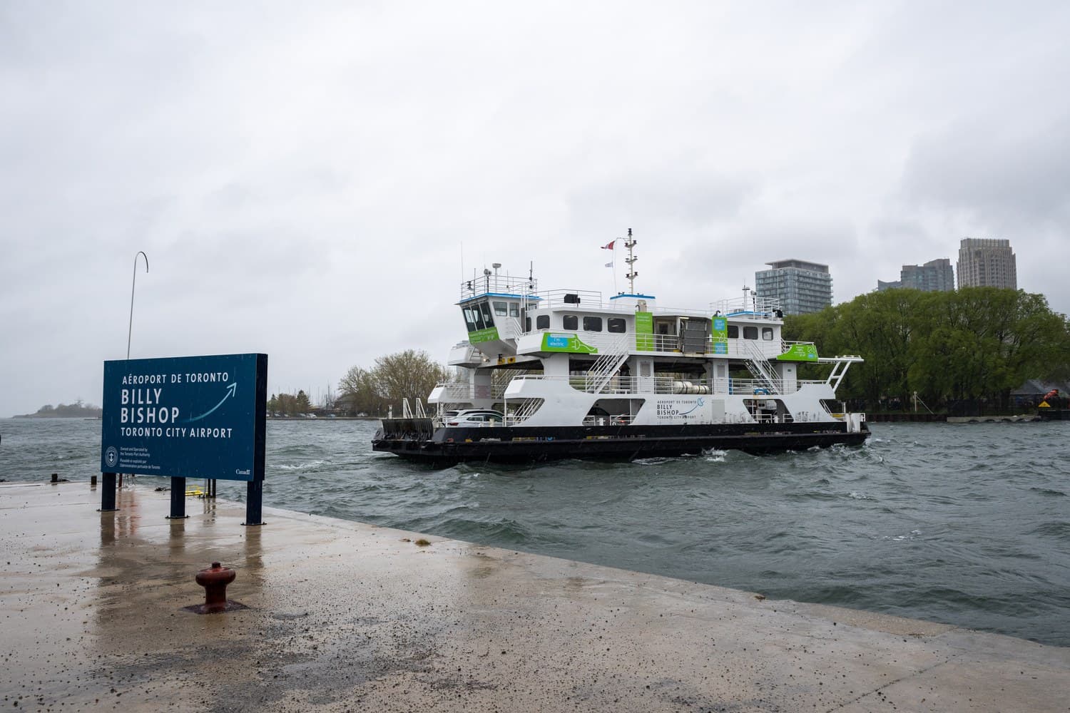 The Marilyn Bell ferry crossing the channel beside a Billy Bishop Airport sign