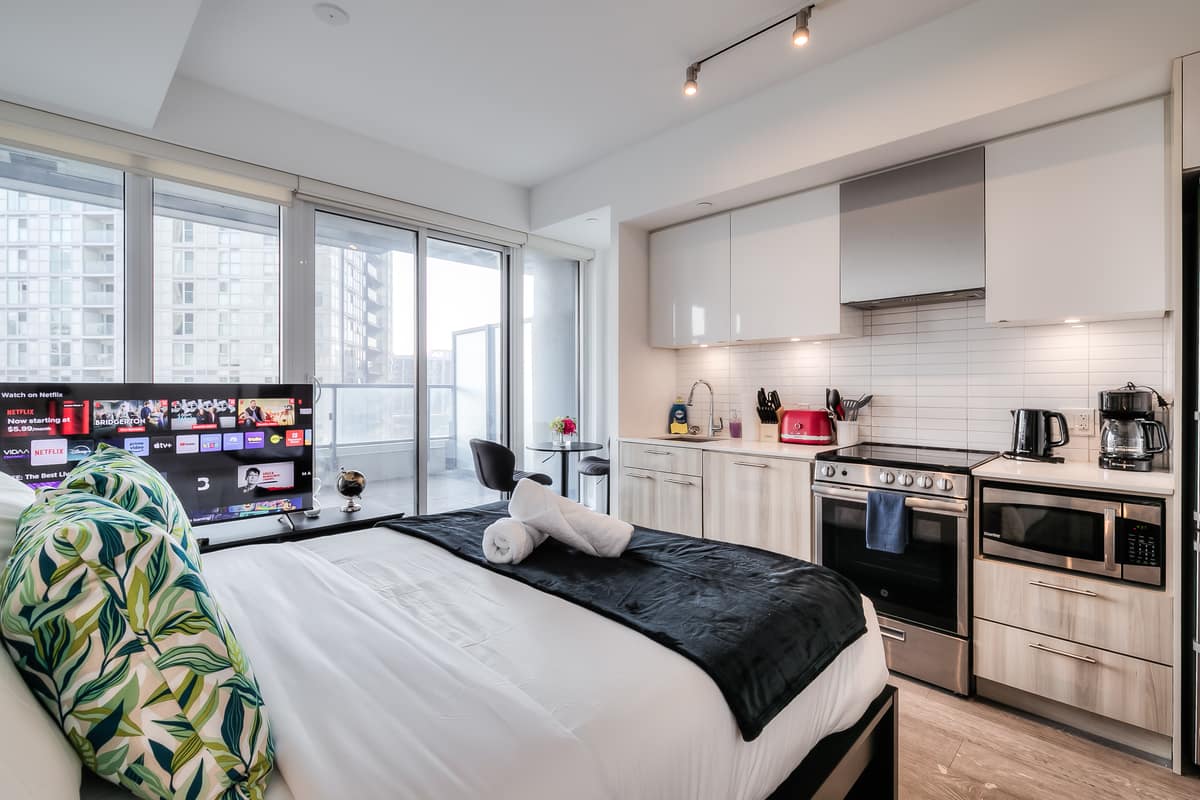 Kitchen, bed and windows in a real StayToronto Jarvis studio suite at 251 Jarvis Street