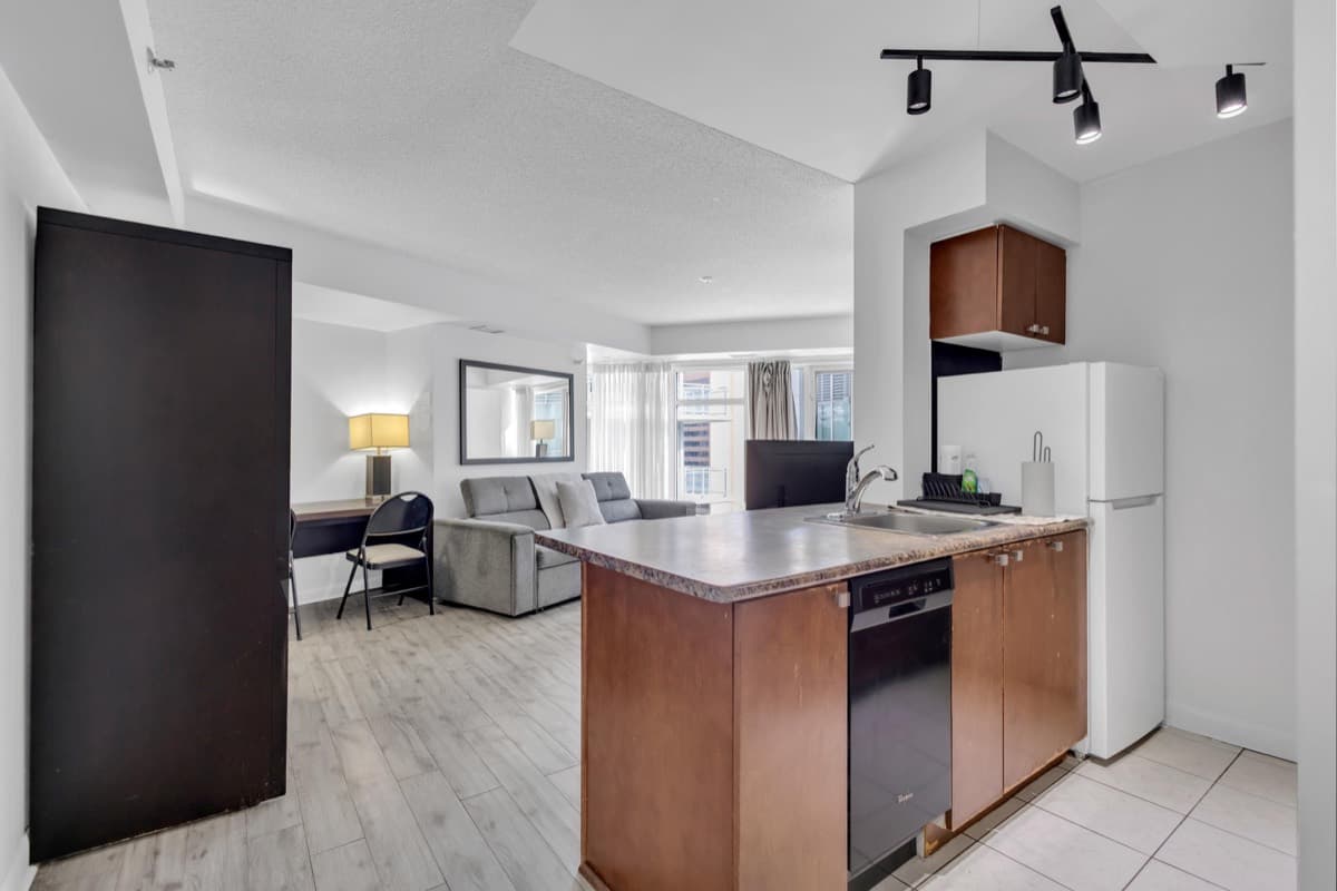 Kitchen, dishwasher and living area in a real StayToronto Pantages one-bedroom suite