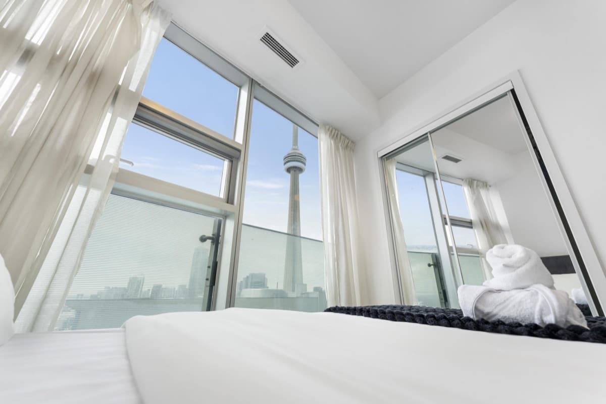 Bedroom in a real York furnished suite at 12 and 14 York Street, South Core, with a CN Tower view