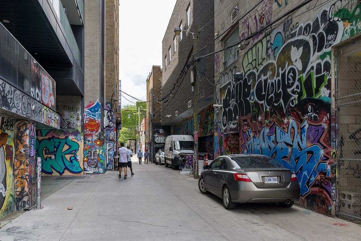 Colourful street art covering both walls of Graffiti Alley on Rush Lane in Toronto