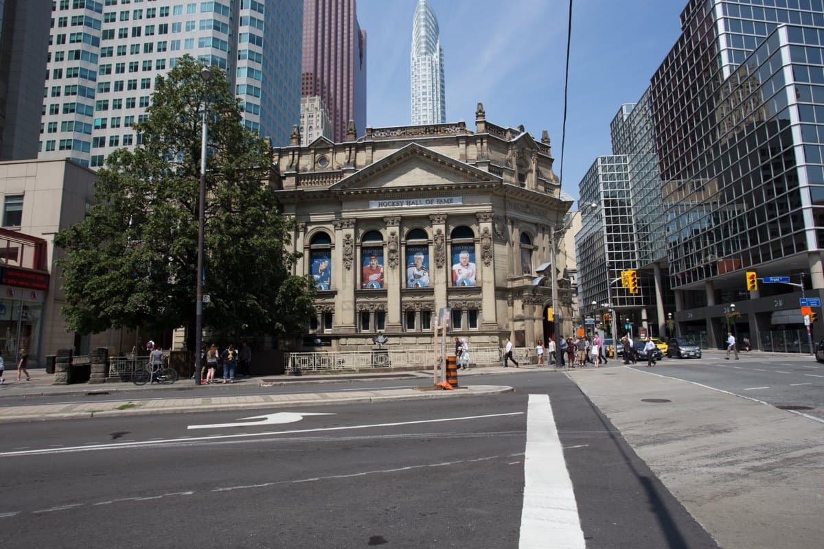 Historic stone Hockey Hall of Fame building with downtown Toronto towers behind it