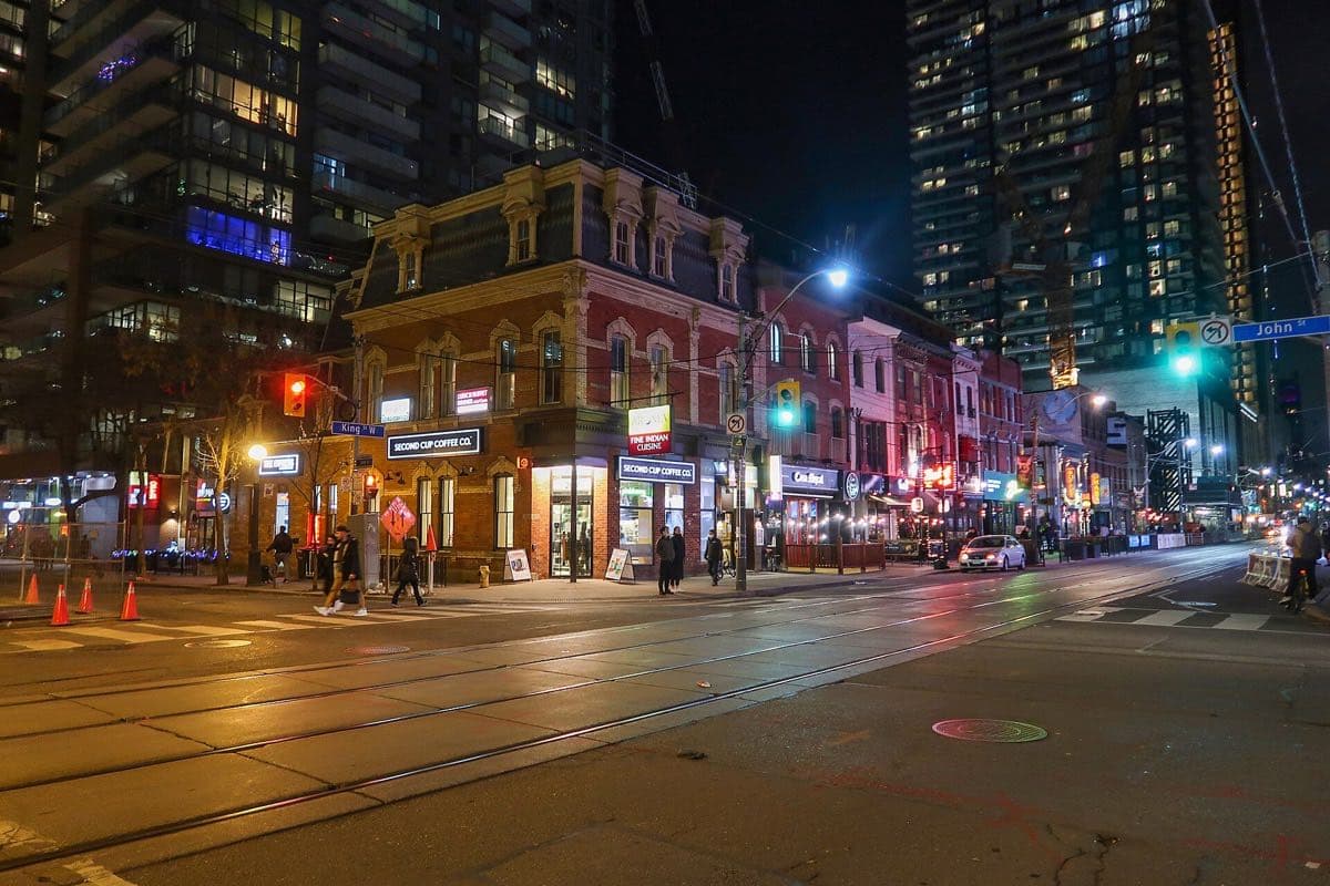 The illuminated patios, signs and traffic of King Street West at night