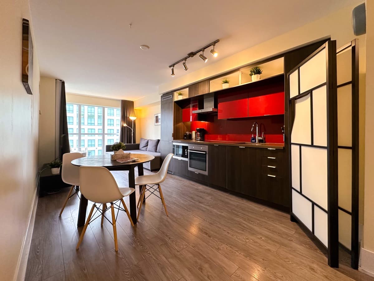 Kitchen, dining area and living room in a real StayToronto Atmos one-bedroom plus den suite