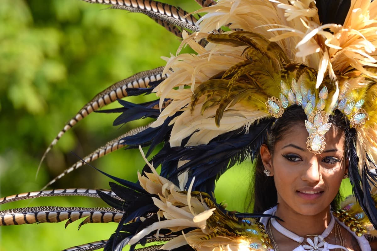 Toronto Caribbean Carnival masquerader wearing an elaborate feathered costume