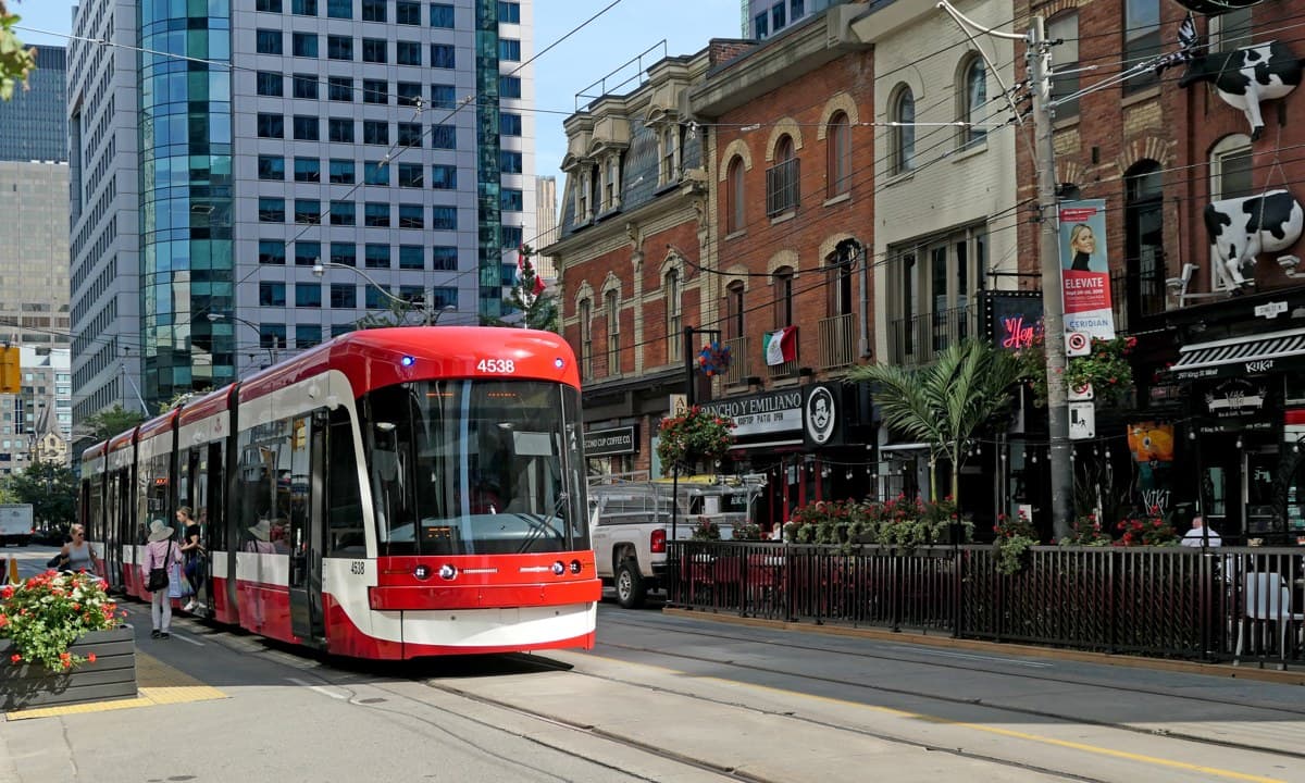 Red and white TTC Flexity streetcar on King Street in Toronto