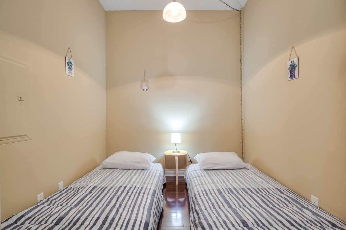Two single beds in the photographed den of a real Yonge one-bedroom plus den suite